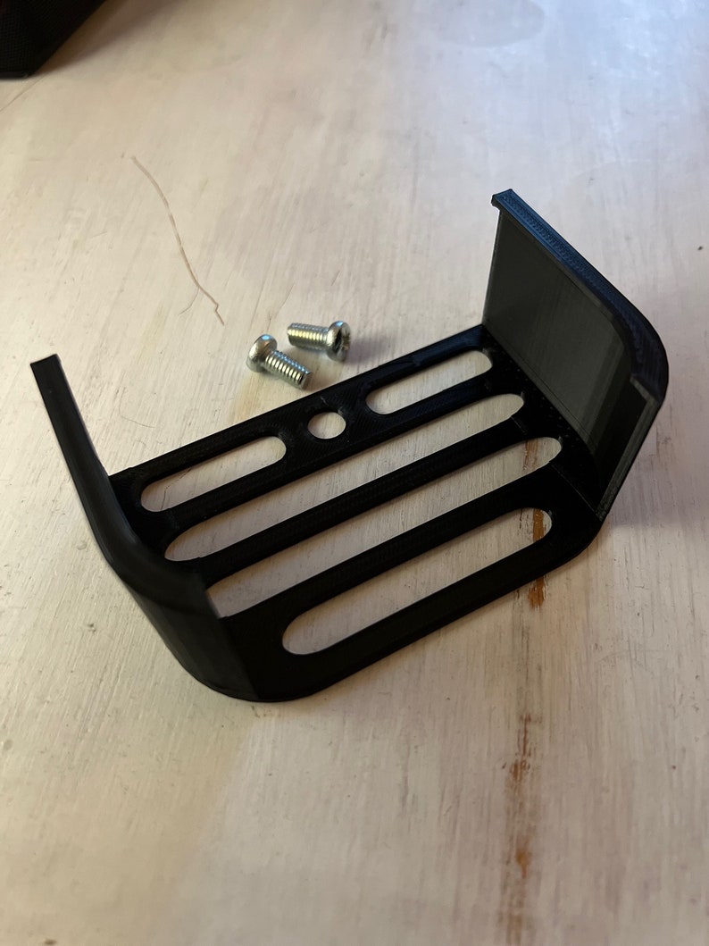 May include: Black plastic 3D printed bracket with four slots and two small silver screws.