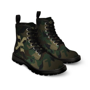 May include: A pair of black and green camouflage print boots with black laces. The boots have a large gold letter 'X' on the side.