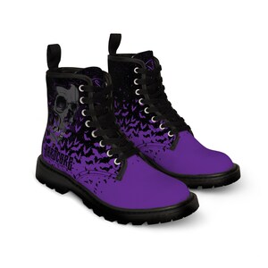 Peut inclure: Bottes de combat violettes et noires avec un motif de crâne et de chauve-souris et le texte "HARDCORE" sur le côté.