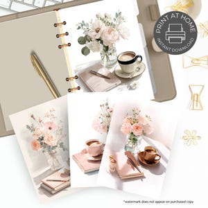 May include: A beige planner with gold accents, featuring watercolor art prints of flowers, coffee, and notebooks. The prints include the text "Print at Home Instant Download". Gold paper clips and a pen are also visible.