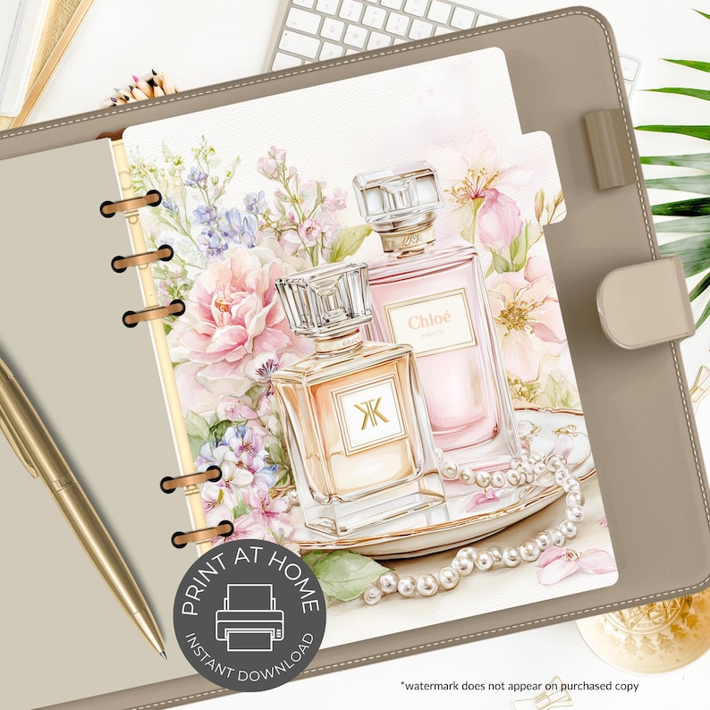 May include: A planner insert featuring two perfume bottles with floral accents and a pearl necklace. The bottles are in shades of peach and pink, with the word "Chlo&eacute;" visible on one. The insert is inside a tan planner with a gold pen.