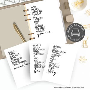 May include: A planner with motivational quotes printed on white cards. The quotes are in black font and include phrases like "You don't have to have it all figured out" and "Small steps repeated with intention create unstoppable momentum."