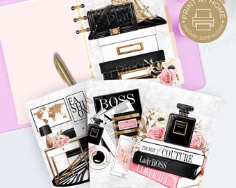May include: A planner with fashion-themed inserts. The inserts feature illustrations of a black quilted handbag, gold heels, perfume, books, and a desk. The planner is pink with gold accents and a gold pen.