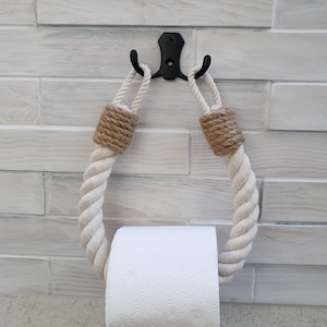 Porta carta igienica fatto a mano in corda di cotone con involucro di juta e gancio in metallo. Decorazione rustica per il bagno