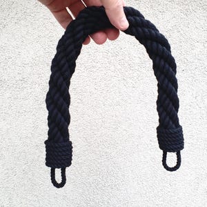 以下が含まれることがあります： 両端にループが付いた黒い編み込みロープのハンドル。ハンドルは厚くねじれたロープで作られています。