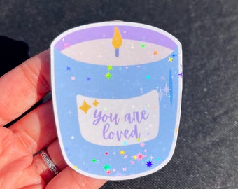 May include: A blue and white candle sticker with glitter and the text "you are loved".