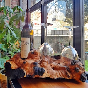 Può includere: Un porta bottiglie di legno con due bicchieri da vino e una bottiglia di vino "Bernet's Merlot-Syrah".