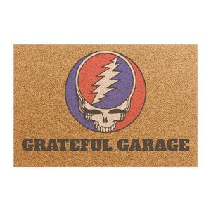 May include: A rectangular doormat with a brown coir surface. The design features a skull with a lightning bolt on a red and purple circle. The words "GRATEFUL GARAGE" are printed in dark brown.
