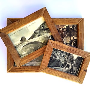 Può includere: Tre cornici vintage in legno con fotografie in bianco e nero. Le cornici sono in legno marrone chiaro e sono disposte in una composizione a strati. Le fotografie raffigurano scene di un ponte, una seggiovia e un tunnel.