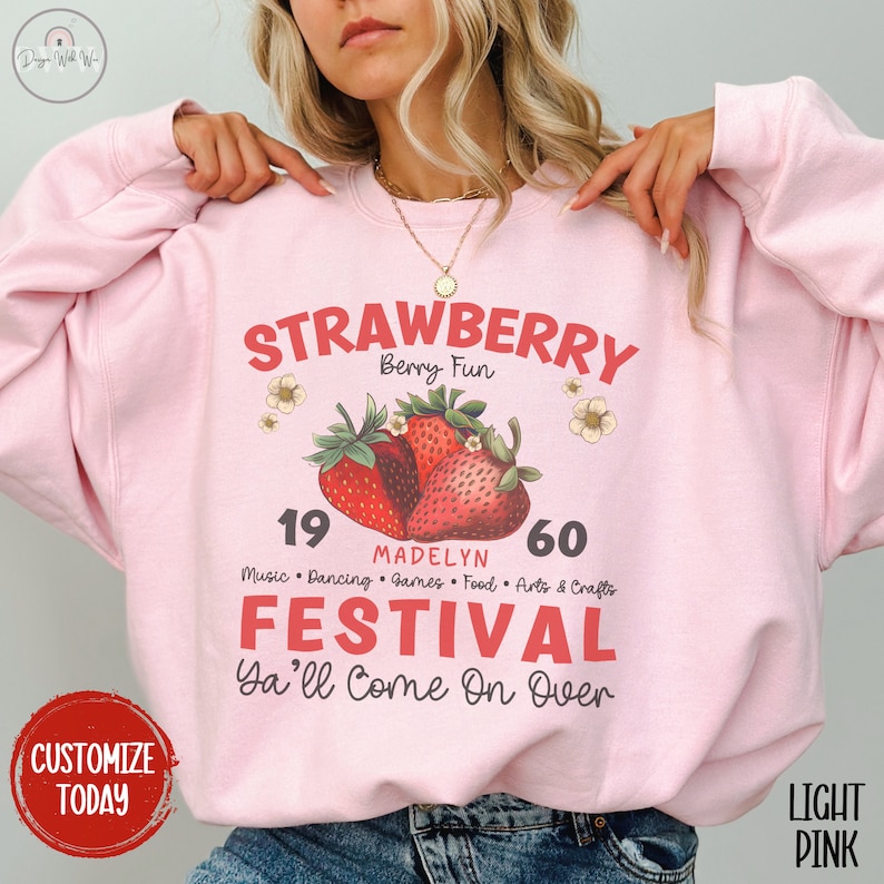 May include: A light pink sweatshirt with a graphic design of strawberries and the text "STRAWBERRY Berry Fun 19 MADELYN 60 Music Dancing Games Food Arts & Crafts FESTIVAL Ya'll Come On Over".