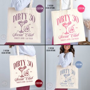 May include: A white canvas tote bag with a pink design that says "Dirty 30 Social Club Hailey's 30th - Las Vegas". The design includes a cocktail glass with a lime wedge and a sprig of rosemary.