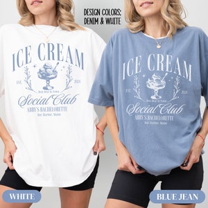 May include: Two oversized t-shirts with a blue ice cream graphic and the text "ICE CREAM EST. 2024 Best Deal In Town Social Club ABBY'S BACHELORETTE Bar Harbor, Maine". The t-shirts are shown in white and blue jean colors.