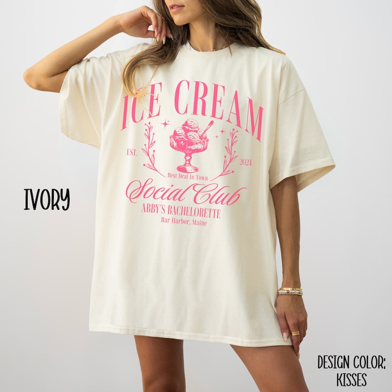 May include: Ivory t-shirt with a pink graphic design that says "Ice Cream Social Club" with a vintage ice cream cone illustration and the text "Est. 2024" and "Abby's Bachelorette, Bar Harbor, Maine".