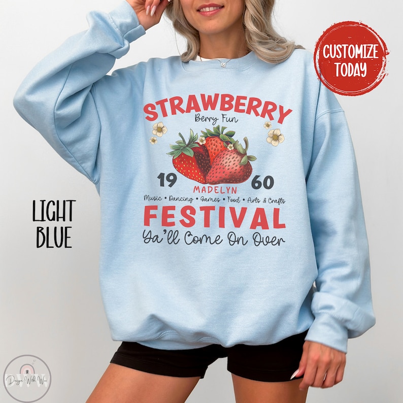 May include: Light blue sweatshirt with a graphic design of strawberries and the text "STRAWBERRY Berry Fun 19 MADELYN 60 Music Dancing Games Food Arts & Crafts FESTIVAL Ya'll Come On Over"