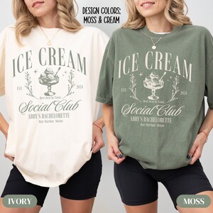 May include: Two t-shirts with the text "ICE CREAM Social Club" in a vintage style font. The text is in cream on a moss green t-shirt and in moss green on a cream t-shirt. The text "ABBY'S BACHELORETTE" is below the main text. The t-shirts are shown on models wearing black shorts.
