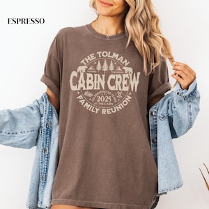 May include: Espresso-colored t-shirt with a circular graphic that reads "The Tolman Cabin Crew Family Reunion 2025." The design includes bears, trees, and the words "Making Memories." The shirt is a relaxed fit.