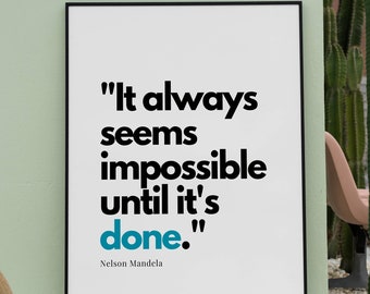 May include: A black framed poster with a white background and a quote in black text: "It always seems impossible until it's done." The quote is attributed to Nelson Mandela in smaller black text below. The poster is hanging on a light green wall.