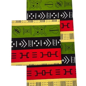 May include: A vibrant textile featuring a repeating pattern of geometric shapes and symbols in red, black, green, and yellow. The design includes vertical stripes and stylized motifs, creating a bold and colorful aesthetic. The fabric is likely used for clothing or home decor.