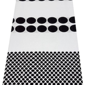 May include: White fabric with a repeating pattern of black ovals and dots. The top section features rows of large ovals, followed by a section of smaller dots, and a striped border with the number "250603".