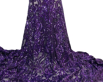 May include: A close-up of a flowing fabric with a detailed, ornate pattern. The fabric is a deep purple color, covered in shimmering sequins. The design features swirling, floral-like motifs, creating a luxurious and elegant appearance. The fabric appears to be a high-end textile.