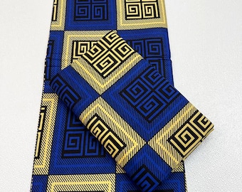 May include: Blue and gold patterned fabric with a geometric design. The fabric features a repeating pattern of squares and diagonal lines, with black and gold geometric shapes. A folded piece of the same fabric is also present.