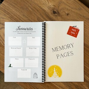 May include: A white and grey journal with a spiral binding. The front cover has the text "Favourites" and a section for writing down favourite things from a Disney trip. The back cover has the text "Memory Pages" and a yellow silhouette of Cinderella's castle.