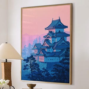 May include: A framed print of a Japanese castle in blue and pink tones hangs above a marble-topped table. A wooden lamp with a cream shade, a vase of white flowers, and two white ottomans with wooden legs complete the room's decor.