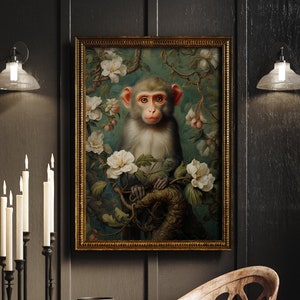 May include: A framed vintage painting of a monkey amidst white flowers and green leaves. The artwork features a gold ornate frame and is displayed in a room with dark walls, a wooden table, and candle holders.
