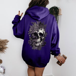 May include: Purple hoodie with a skull and floral design on the back.