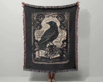 May include: Black and white woven throw blanket featuring a vintage illustration of a crow perched on a branch. The illustration is surrounded by a decorative frame with the text "Cogito Ergo Sum" and "Difficile est Satyram Non Scribere".