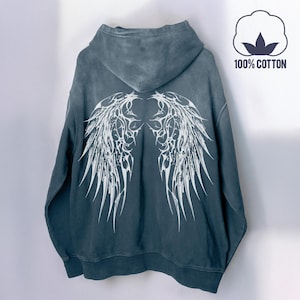 May include: A dark teal hoodie with a white wing design on the back. The hoodie has a hood and a kangaroo pocket. The image also includes a cotton symbol with the text "100% COTTON".