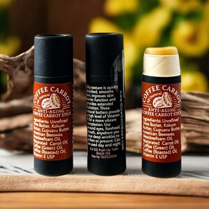Puede incluir: Tres barras de b&aacute;lsamo labial anti-edad Coffee Carrot. Las barras est&aacute;n en tubos negros con etiquetas marrones. Las etiquetas enumeran ingredientes como manteca de karit&eacute; y aceite de caf&eacute;. El texto de la etiqueta dice "GlowUntilDawn.com".
