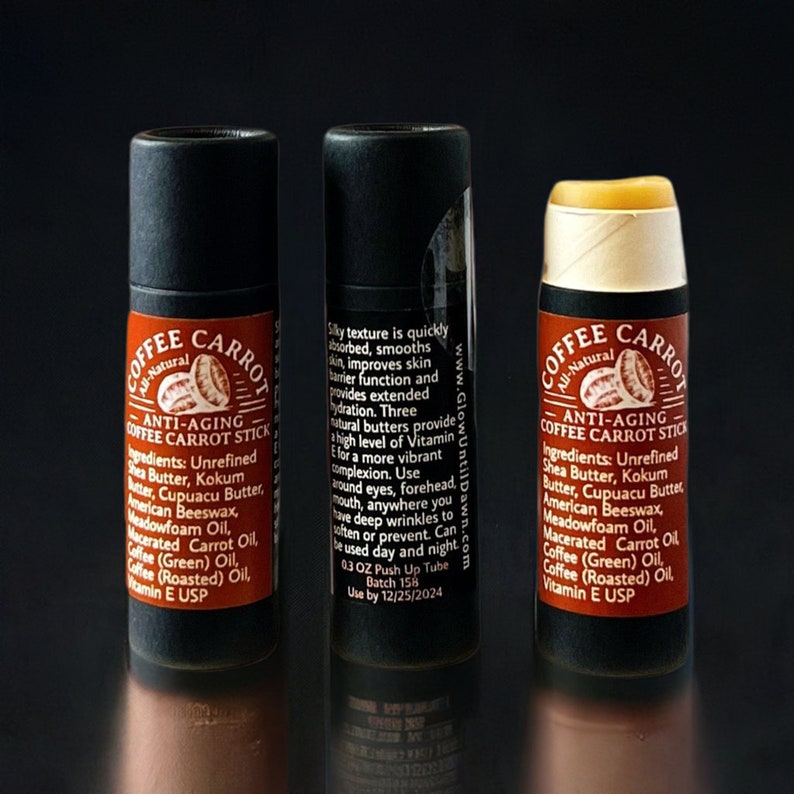 Puede incluir: Tres b&aacute;lsamos labiales Coffee Carrot Stick antiedad. Los tubos negros tienen una etiqueta marr&oacute;n con el nombre del producto y los ingredientes. El b&aacute;lsamo abierto es de color amarillo claro. El texto de la etiqueta incluye los ingredientes y las instrucciones de uso.