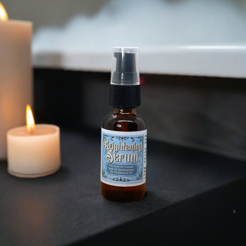 May include: A small brown glass bottle with a black pump top and a blue and white label that reads "Brightening Serum". The label lists the ingredients: Chia Seed Oil, Pumpkin Seed Oil, Sea Buckthorn Oil, Frankincense EO.