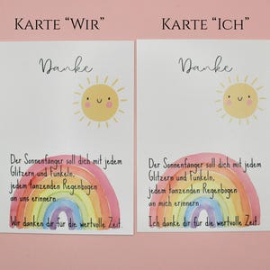 May include: Two white cards with a watercolor rainbow and sun illustration. The cards have the word "Danke" at the top, with German text below. The text includes phrases like "glitter and sparkle" and "rainbow".