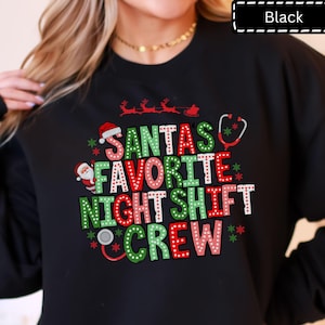 May include: A black long-sleeve sweatshirt featuring a graphic with the text "SANTA'S FAVORITE NIGHT SHIFT CREW" in red, green, and white polka-dot letters. The design includes a Santa Claus figure, a stethoscope, and a reindeer sleigh.