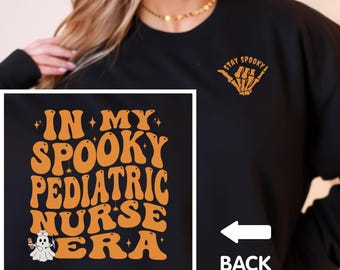 May include: Black sweatshirt with the text "IN MY SPOOKY PEDIATRIC NURSE ERA" in orange, with a ghost graphic. The back of the sweatshirt has the word "BACK" and a skeleton hand graphic that says "STAY SPOOKY".