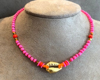 Pink beaded necklace with gold cowrie shell charm