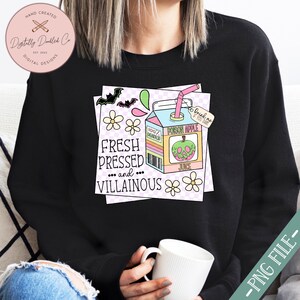 May include: A black sweatshirt with a graphic of a cartoon juice box with a green apple and the text "Fresh Pressed and... Villainous" and "Poison Apple Juice" on it. The juice box is surrounded by pink and white flowers and bats.