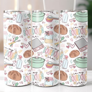 Pu&ograve; includere: Tumbler bianco con un motivo ripetuto di pane a lievitazione naturale, utensili da cucina, cuori e il testo "in my sourdough era".