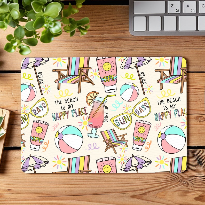 May include: A colourful beach-themed mouse mat with illustrations of beach chairs, sunglasses, beach balls, and a drink with a straw. The text "The beach is my happy place" is repeated on the mouse mat.