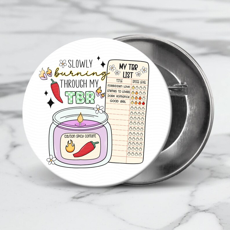 May include: A white button with a colorful illustration of a candle with a red chili pepper and the text "Slowly burning through my TBR".  The button also features a list titled "My TBR List" with a spice level chart.