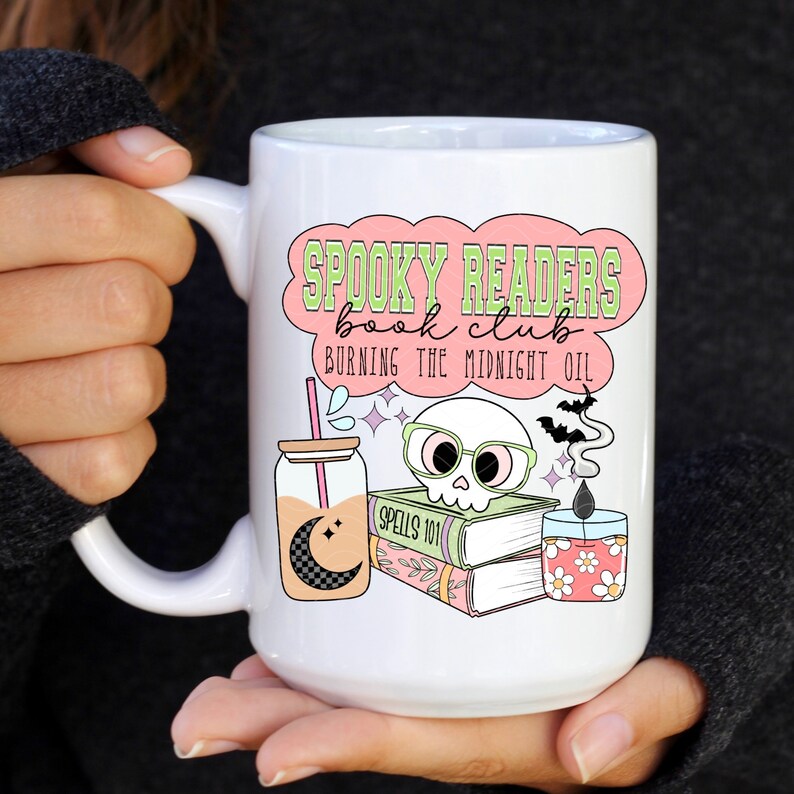 May include: White ceramic mug with a pink and green design that says "Spooky Readers Book Club Burning the Midnight Oil". The design also includes a skull wearing glasses, a book stack, a jar with a straw, and a candle.
