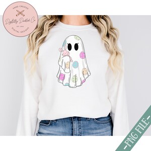May include: A white ghost with a pink bunny rabbit inside. The ghost is decorated with pastel colored polka dots.