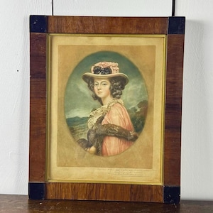 May include: A framed portrait of a woman wearing a pink hat with a white feather. The portrait is set against a landscape background and is signed in the bottom right corner.