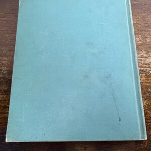Puede incluir: Un libro de tapa dura de color azul verdoso con una portada lisa.