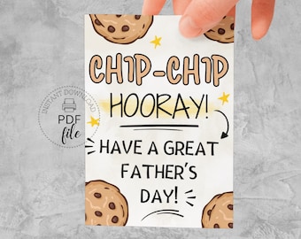 Puede incluir: Una tarjeta del Día del Padre con temática de galletas. La tarjeta dice "CHIP-CHIP HOORAY! HAVE A GREAT FATHER'S DAY!" y presenta ilustraciones de galletas con chispas de chocolate y estrellas amarillas. La tarjeta está sostenida por una mano.