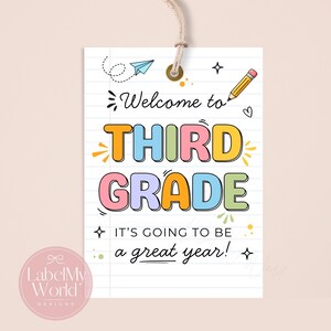 May include: A rectangular paper tag with a white lined notebook background, featuring the text Welcome to THIRD GRADE IT'S GOING TO BE a great year! in colourful bubble letters, decorated with a pencil, paper aeroplane, and small star icons.