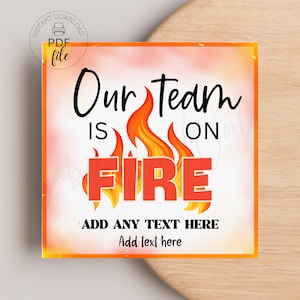 May include: A printable sign with a white background and orange border. The text "Our Team is on FIRE" is in black with a red flame graphic. The text "ADD ANY TEXT HERE" is in black and the text "Add text here" is in black.