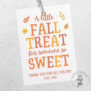 Può includere: Biglietto regalo bianco con il testo "A little FALL TREAT for someone so SWEET" in arancione e giallo. Include illustrazioni di foglie autunnali e il testo "THANK YOU FOR ALL YOU DO! LOVE, JULIE."